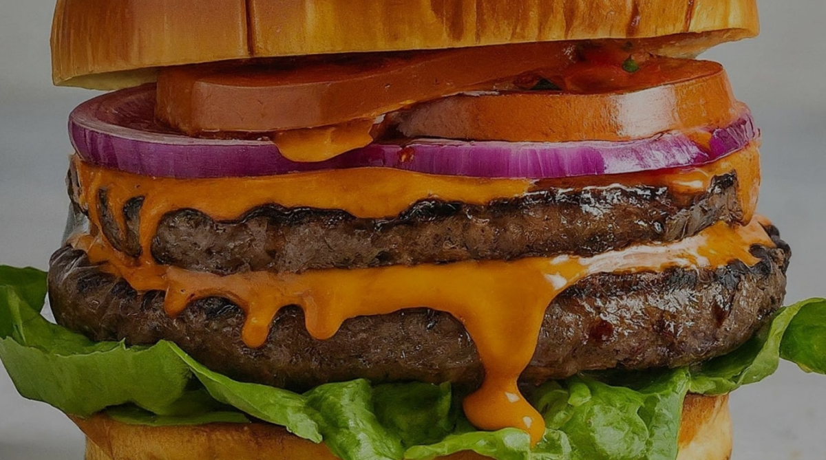 burger with lettuce, tomato, onion, sauce, brioche bun